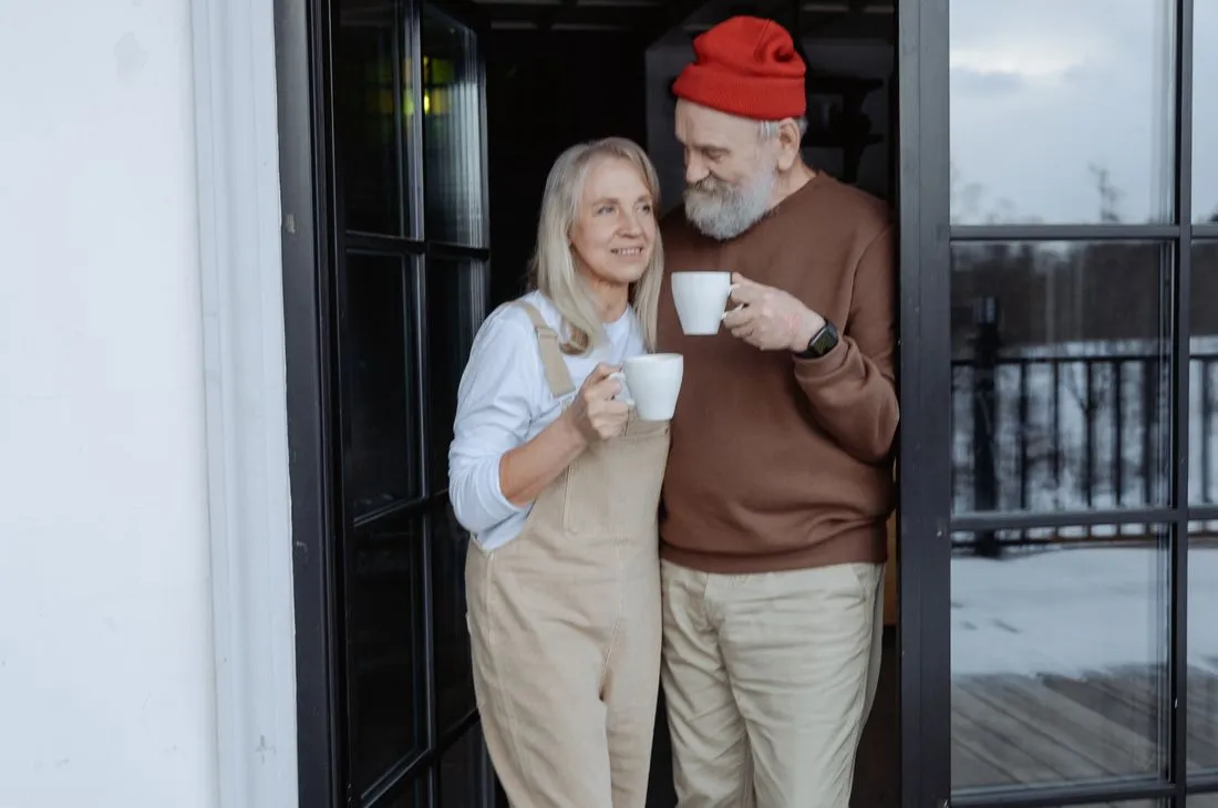Couple in their seventies laughing together on a porch